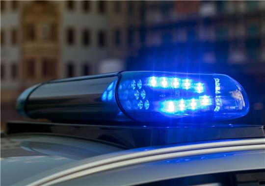 Das Blaulicht auf einem Fahrzeug der Polizei leuchtet in der Dunkelheit.