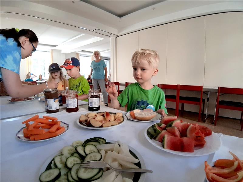 Wald und Natur stehen im Mittelpunkt Das Büfett ist eröffnet: Jedes Ferienkind kann wählen, was es gerne frühstücken möchte. Am großen Tisch vor der langen Fensterreihe des Gemeindesaals sitzen sie dann zusammen und tanken Energie für die Aktionen des Tages. Es ist auch viel Zeit für ausführliche Gespräche, was Pastor André Dittmann als wichtig erachtet. Fotos: Potthast