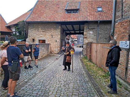 Das Dammtor ist das einzig Erhaltene von einstmals fünf Hornburger Stadttoren. Die Gäste lauschen konzentriert Herbert Grünhages Berichten und Anekdoten aus längst vergangenen Tagen. Foto: Hohaus