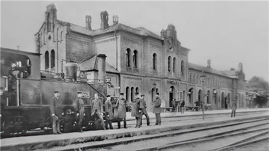 Ein Schwarz-Weiß-Foto, das Ende des 20. Jahrhunderts entstanden ist. Es zeigt die Gleise und das Bahnhofsgebäude