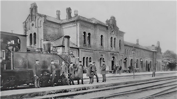Ein Schwarz-Weiß-Foto, das Ende des 20. Jahrhunderts entstanden ist. Es zeigt die Gleise und das Bahnhofsgebäude
