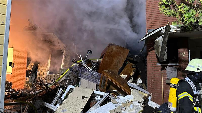 Zu sehen sind durch das Feuer zerstörte Möbel, die vor dem brennenden Haus auf einem Haufen liegen.