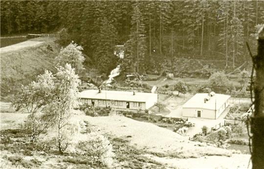 Das Foto zeigt das Barackenlager im Wintertal unterhalb des Herzberger Teiches in der Nachkriegszeit, zirka 1946 /47. Rechts ist die Waschbaracke, links eine Baracke für die Ex-Zwangsarbeiter aus Westeuropa zu sehen. Die Unterkünfte wurden noch bis weit in die 1950er Jahre benötigt. Foto: Sammlung des Weltkulturerbes Rammelsberg
