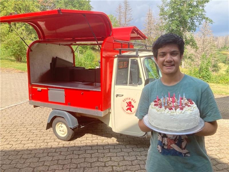 Akshat Kapoor (17) bekommt Geburtstagstorte aus Indien Das Gefährt im Hintergrund kennt Akshat Kapoor aus Indien auch aus seiner Heimat. Andreas Epting bringt die Schwarzwälder Torte stilecht per Ape. Foto: Privat
