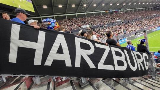 Ein riesiges Transparent mit der Aufschrift HARZBURG hängt in einem vollbesetzten Fußballstadion.