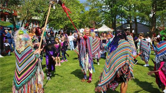 Bunt gekleidete Hexen tanzen im Kurpark von St. Andreasberg.