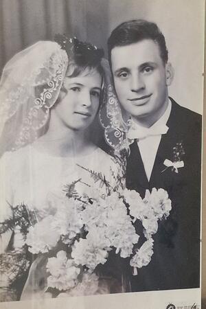 Brautpaar in Hochzeitskleidung mit Brautstrauß und Spitzenhaarschleier