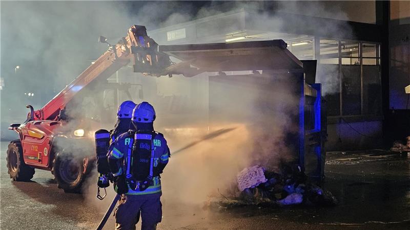 Das Innere des Papiercontainers wird gelöscht: Die Feuerwehr konnte eine Ausbreitung der Flammen verhindern.