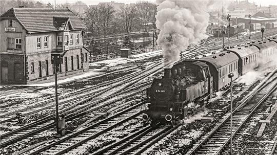 Das Januar-Kalenderblatt zeigt die 64 289 im Bahnhof Goslar im Jahr 1975 – heute ist das Gleisfeld auf das absolute Minimum eingedampft.