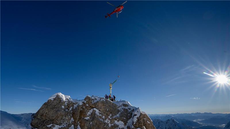 Das Kreuz schwebt am Gipfel ein. 