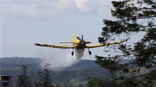 Das Löschflugzeug "Hexe 1" aus dem Harzkreis wirft am Ahrendsberg Wasser ab.