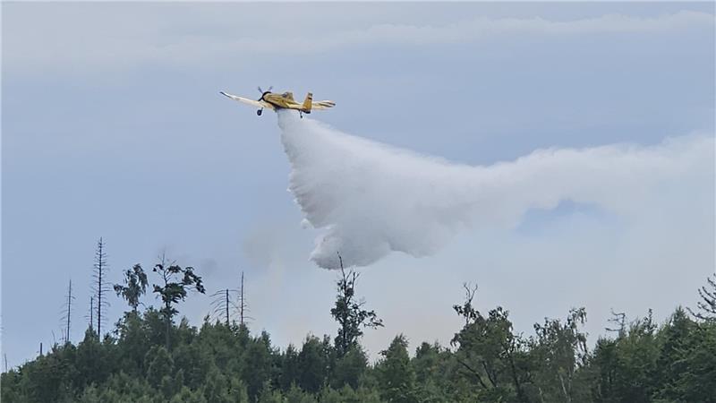 Waldbrand bei Goslar: Feuer unter Kontrolle Das Löschflugzeug „Hexe 1“ wirft Wasser über der brennenden Fläche ab.