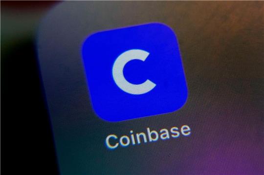 Das Logo der Coinbase-App ist auf dem Bildschirm eines Handys zu sehen.
