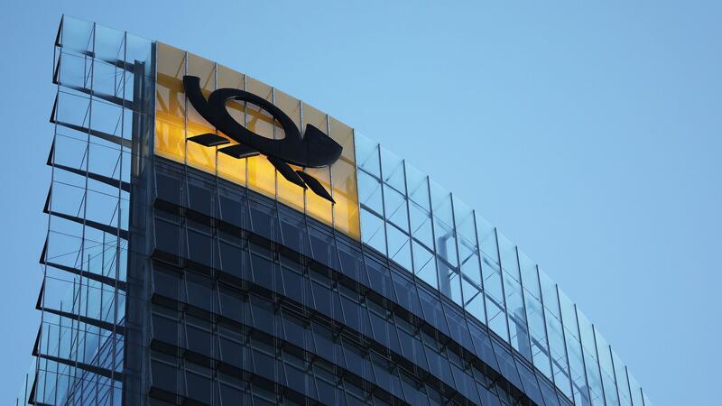 Das Logo der Deutschen Post leuchtet am Post-Tower, dem Unternehmenssitz des Post-Konzerns DHL.