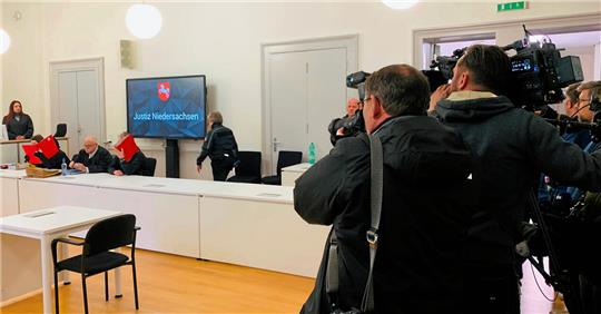 Das Medieninteresse ist groß. Die Angeklagten verbergen ihre Gesichter hinter Aktenordnern.