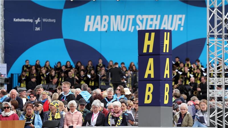 Das Motto des Katholikentags ist auf einer Bühne zu sehen. 
