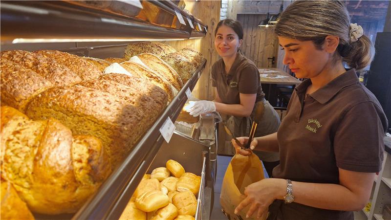 Iranische Mitarbeiterinnen stehen an der Brötchentheke der Bäckerei Moock.