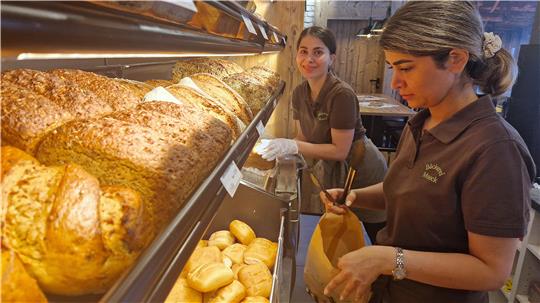 Iranische Mitarbeiterinnen stehen an der Brötchentheke der Bäckerei Moock.