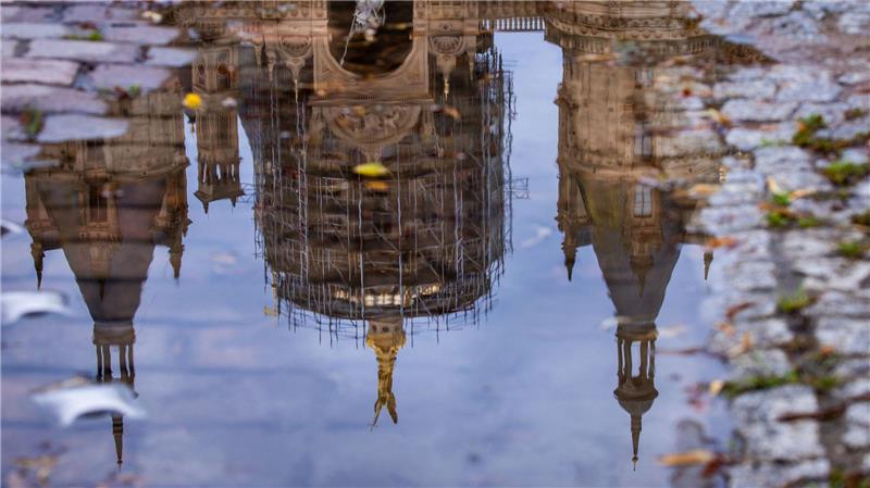 Bilder des Tages Das Schweriner Schloss spiegelt sich in einer Regenpfütze – graues, kühles und regnerisches Wetter zeigt den norddeutschen Sommer von seiner unfreundlichen Seite.