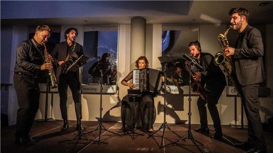 Das Signum Saxophone Quartet und die Akkordeonistin Ksenija Sidorova sind schwarz und elegant gekleidet. Sie spielen auf einem Podest im Pulverhaus der Firma Sympatec.
