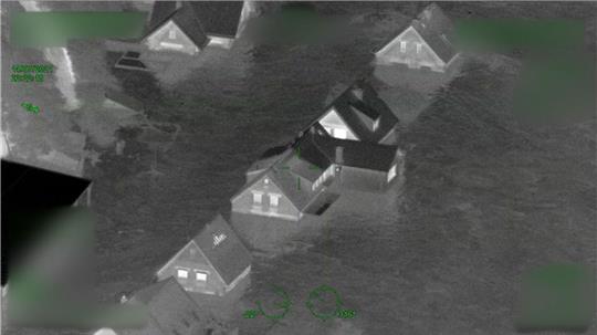 Das Standbild aus einem der Polizeivideos zeigt Häuser im Ahrtal, die bereits vom Wasser eingeschlossen sind.