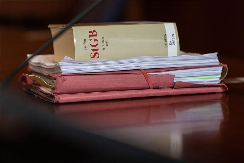 Sexueller Missbrauch in Kita: Bewährungsstrafe für Erzieher Das Strafgesetzbuch und Akten liegen in einem Gericht auf dem Tisch.