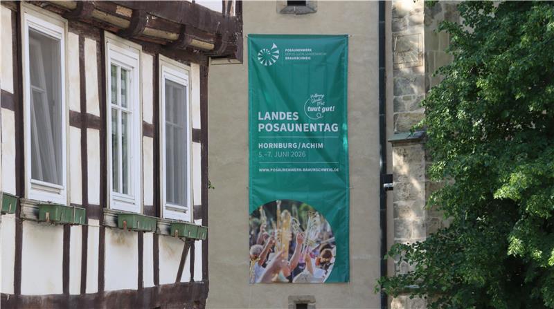An einer Wand hängt ein langes Transparent, das auf den Landesposaunentag hinweist.