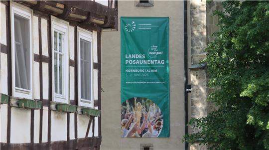 An einer Wand hängt ein langes Transparent, das auf den Landesposaunentag hinweist.