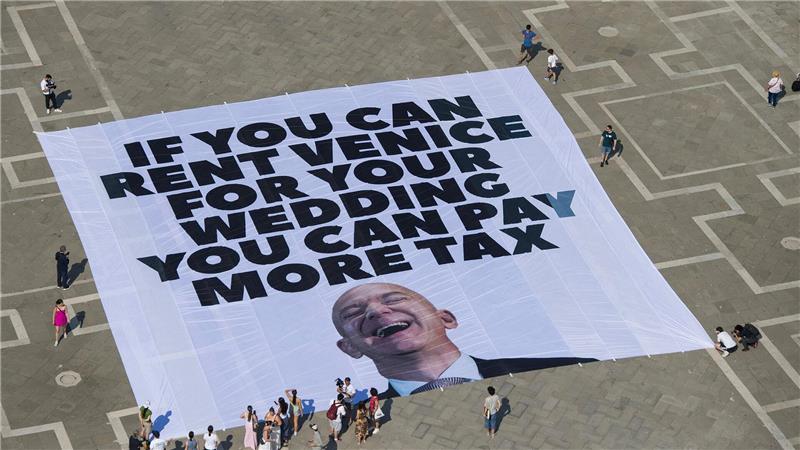 Amazon-Gründer Bezos und Braut zu Hochzeit eingetroffen Das Transparent zeigt ein Foto des Amazon-Gründers, auf dem steht: „If you can rent Venice for your wedding you can pay more tax“.