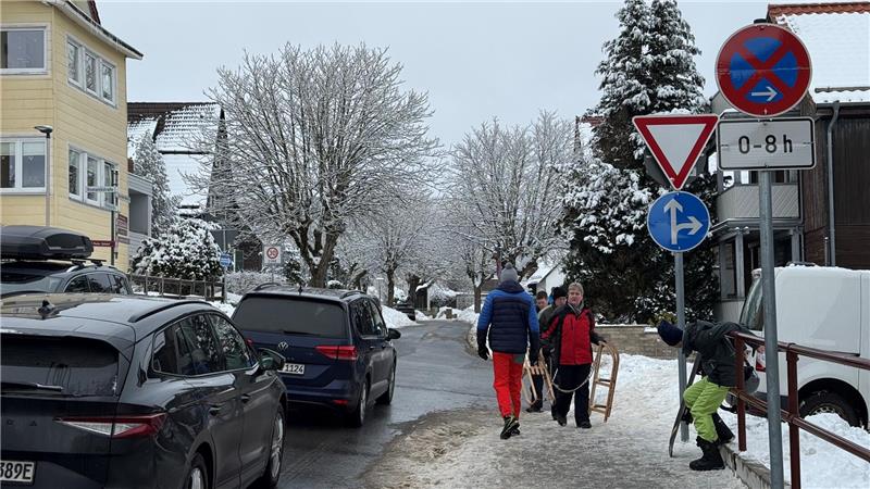 Eine Straße mit Autos, Menschen und Straßenschildern.