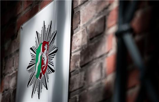 Das Wappen der Polizei Nordrhein-Westfalen hängt an der Wand eines Polizeipräsidium.