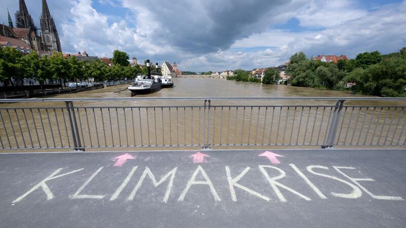 Bange Stunden an der Donau - Weitere Tote in Bayern entdeckt Das Wort „Klimakrise“ ist auf einer Brücke über der Donau in Regensburg zu lesen.
