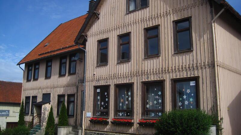 Verzögert sich die Sanierung der Grundschule um ein weiteres Jahr? Das denkmalgeschützte alte Schulgebäude in Hohegeiß ist in keinem guten Zustand. Da sorgen die blühenden Balkonkästen denn auch nur bedingt für eine Verschönerung.