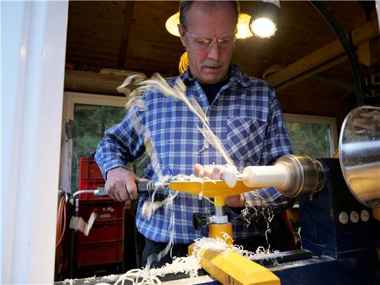 Das eingespannte Holzstück wird maschinell zum Drehen gebracht. Wenn Flemming Gloyer dann sein Eisen ansetzt, um die gewünschte Form zu erhalten, kommt es zum Spänenflug. Fotos: Potthast