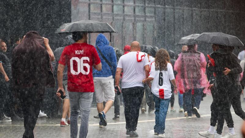 Unwetter in Teilen Deutschlands - Fanzonen betroffen Das haben sie sich sicherlich anders vorgestellt: Fussballfans in Dortmund laufen im strömenden Regen zum Stadion.