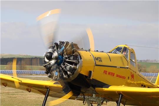 Ein gelbes Flugzeug mit drehendem Rotor.