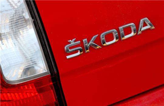 Das klassische Skoda-Logo, noch mit dem Häkchen über dem S, aufgenommen an der Rückseite eines Fahrzeugs.