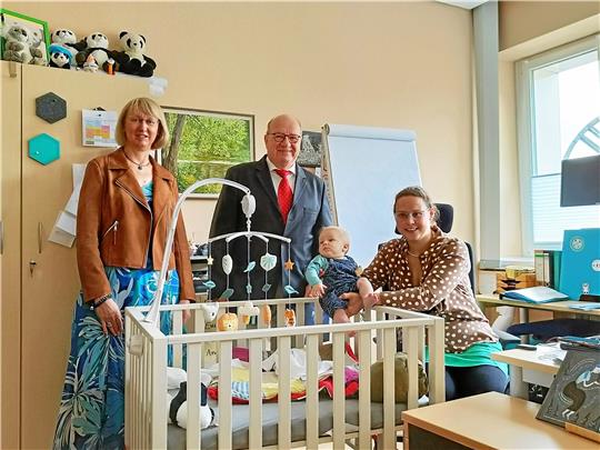 Das mobile Eltern-Kind-Büro ermöglicht Eltern mit kleinen Kindern, Beruf und Familie zu vereinbaren. Prof. Heike Schenk-Mathes (links) und Prof. Oliver Langefeld freuen sich mit Mitarbeiterin Angela Binder und ihrem Sohn über die neue Ausstattung. Foto: TU-Familienservice