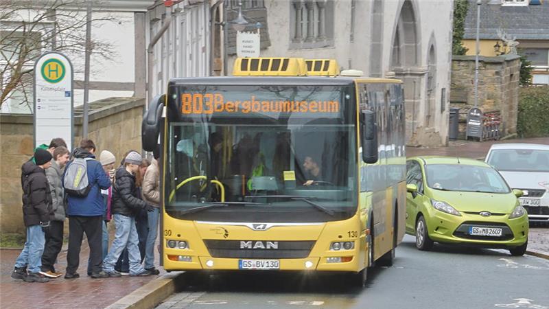 Gelber Linienbus der Linie 803 mit Zielanzeige 'Bergbaumuseum' an einer Haltestelle, an der mehrere wartende Personen stehen