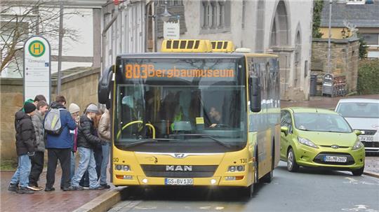 Gelber Linienbus der Linie 803 mit Zielanzeige 'Bergbaumuseum' an einer Haltestelle, an der mehrere wartende Personen stehen