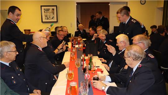 Feuerwehrkameraden sitzen am Tisch