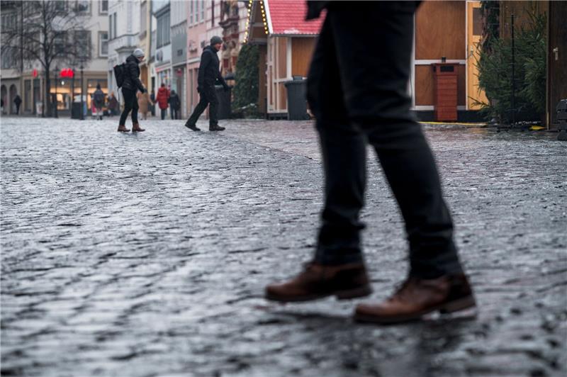 Glatteis: Deutschland rutscht in die Weihnachtswoche Das vereiste Kopfsteinpflaster auf dem Coburger Marktplatz macht es den Fußgängern schwer.
