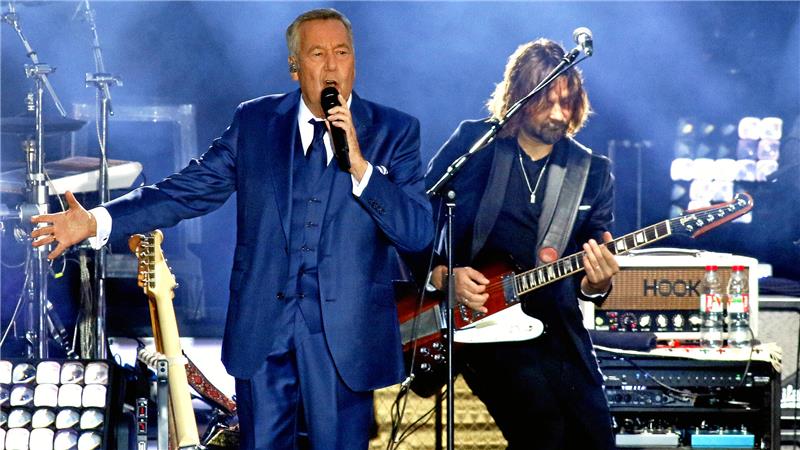 Till Brönner kommt – aber wohin? Kaiserpfalzkonzerte vor Ortswechsel Alter Mann im blauen Anzug singt auf der Bühne. Mann im Hintergrund mit langen Haaren spielt Bass.