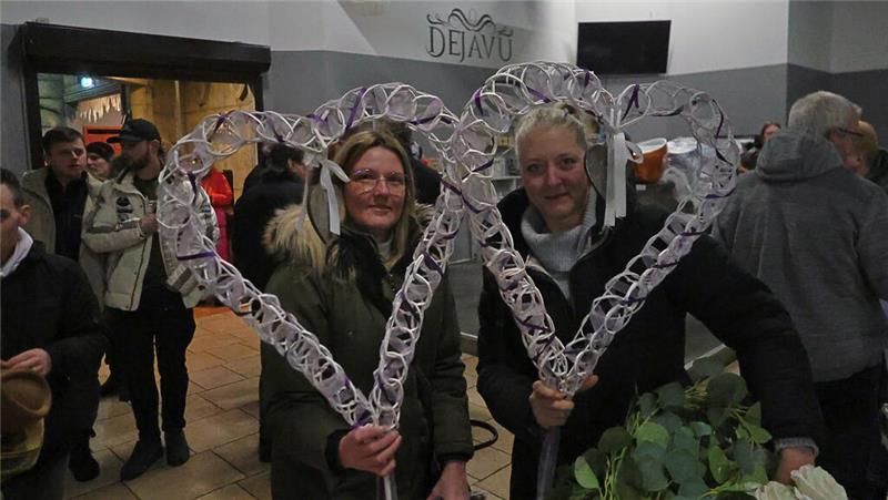 Zwei Frauen halten jeweils ein geflochtenes Herz in der Hand.