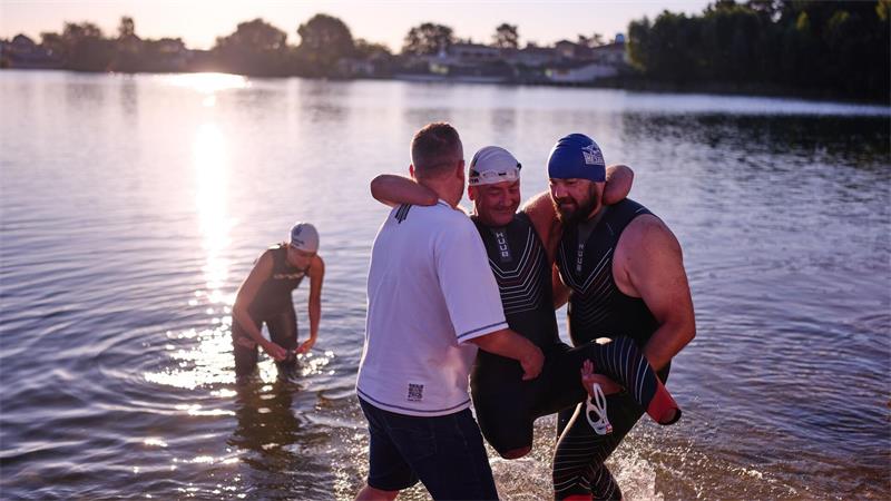 Dem ukrainischen Kriegsveteranen Oleksii Kozak wird bei einer Sportveranstaltung am Rande von Kiew geholfen, aus dem Wasser zu steigen.