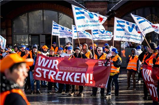 Demonstranten der Eisenbahn- und Verkehrsgewerkschaft (EVG) stehen mit Plakaten vor dem Hauptbahnhof Bremen.