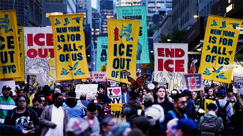 Demonstranten marschieren während einer Protestkundgebung gegen die Einwanderungsbehörde ICE durch die Straßen von New York und halten Plakate.