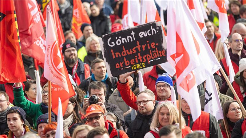 Demonstranten nehmen am bundesweiten Aktionstag der IG Metall teil und stehen im Georgengarten. 