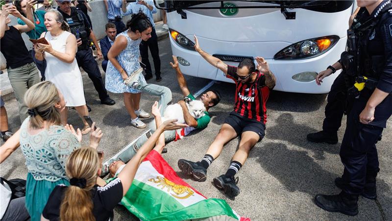 Demonstranten protestierten, während der Bus mit iranischen Spielerinnen und Mitarbeitern abfuhr.