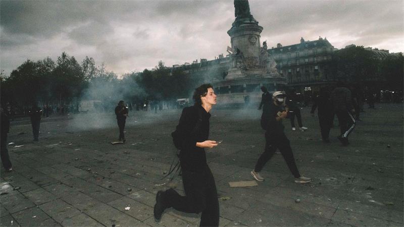 Demonstranten rennen über den Place de la République, während in Paris Tränengas in der Luft hängt.